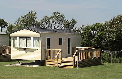 Static holiday caravan with decking area and space for a car